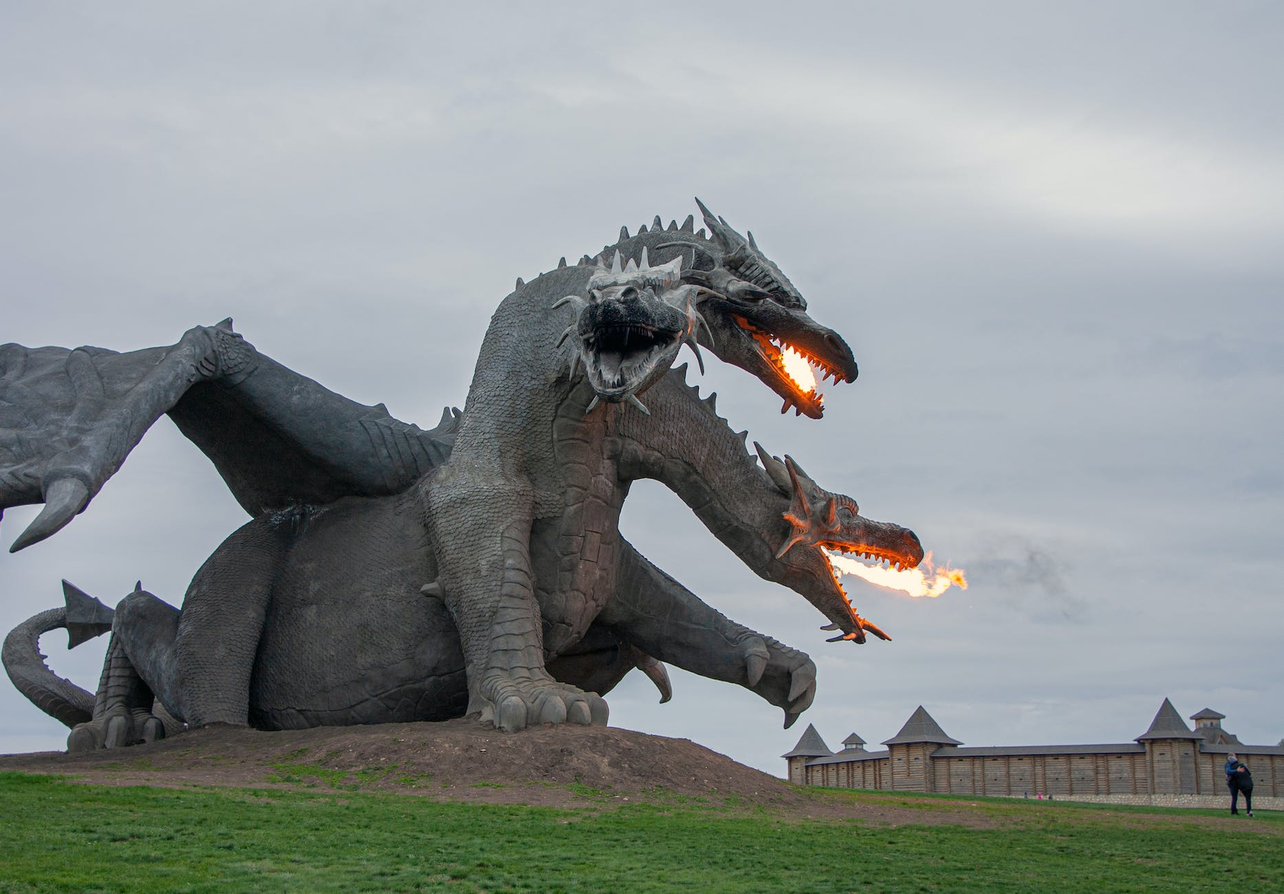 a triple head dragon sculpture in a park